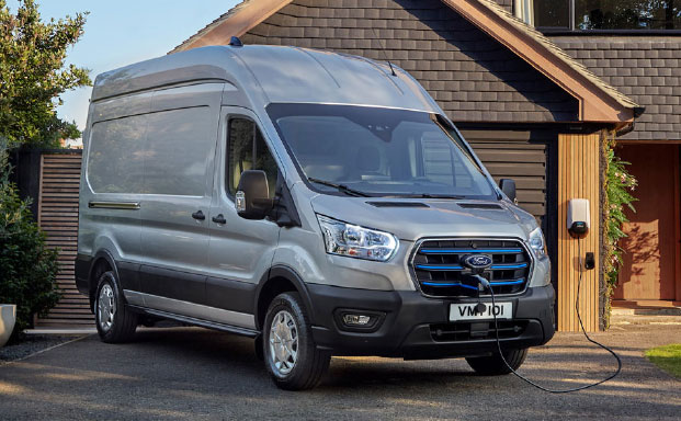 Bild på en silver färgad Ford E-Transit snett fram stillastående som står på laddning